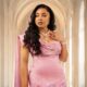 Nollywood actress Linda Ejiofor-Suleiman wearing a custom rose-pink satin dress with 3D embellished floral appliqués and a pearl necklace.