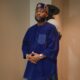 Davido wearing a royal blue velvet tunic, gold embroidered silk wrapper, and customised OBO velvet cap for a traditional Nigerian event.
