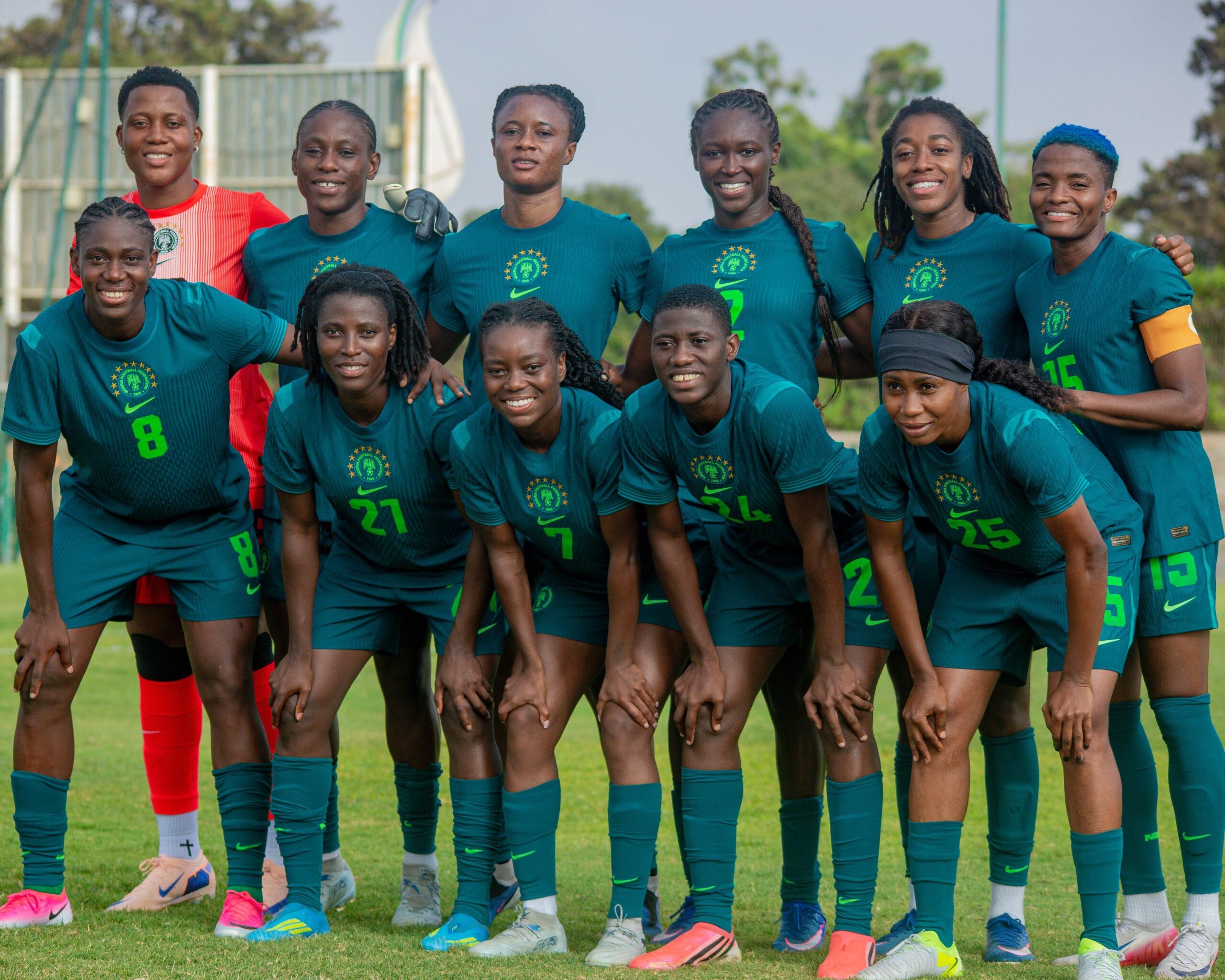 Super Falcons of Nigeria players posing together on the pitch in teal training gear during final match preparations for the 2026 Women's Africa Cup of Nations in Morocco.