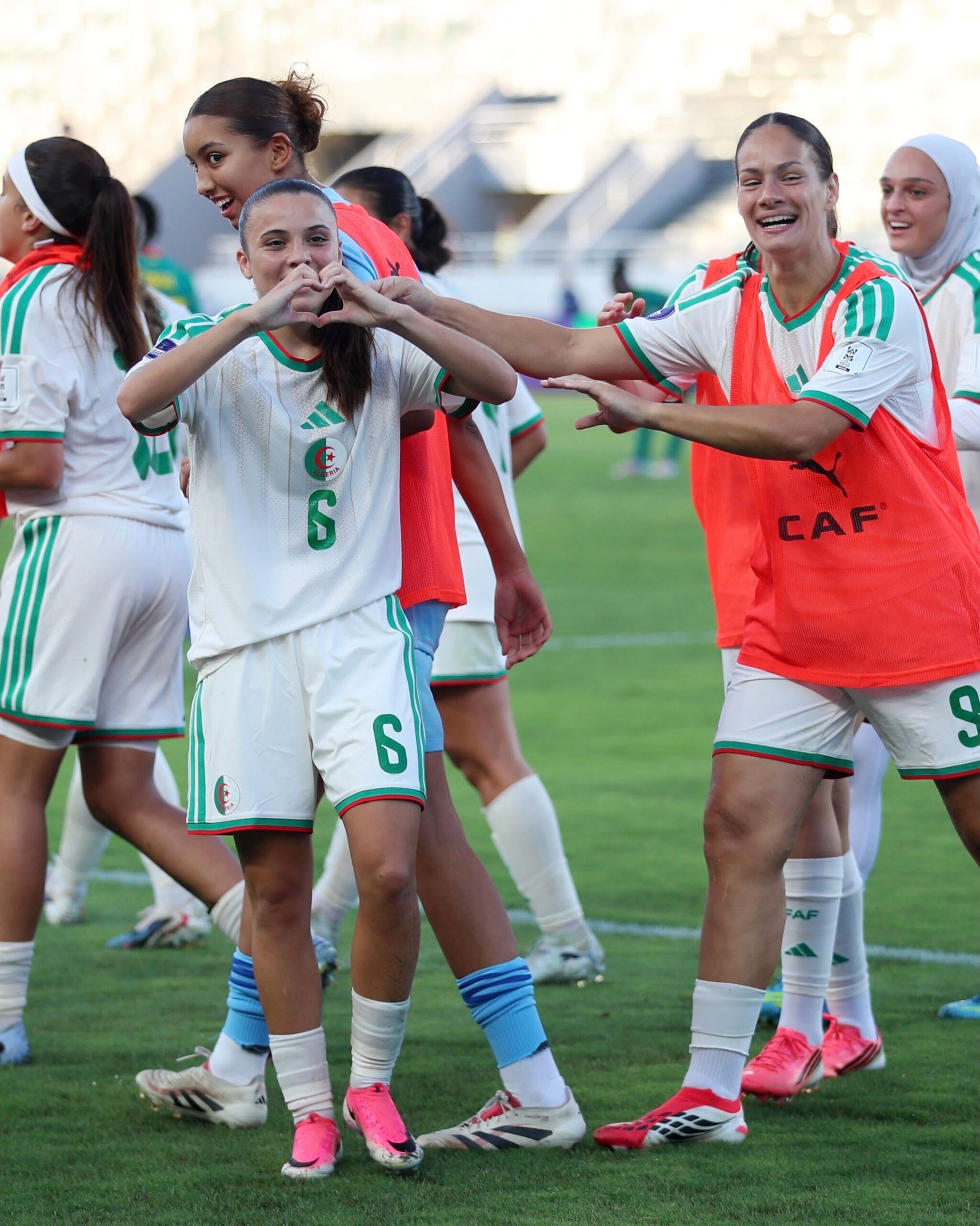 Algerian midfielder Mélissa Bethi forming a heart gesture with her hands to celebrate her 88th-minute goal against Senegal alongside teammates during the WAFCON 2026 opening match.