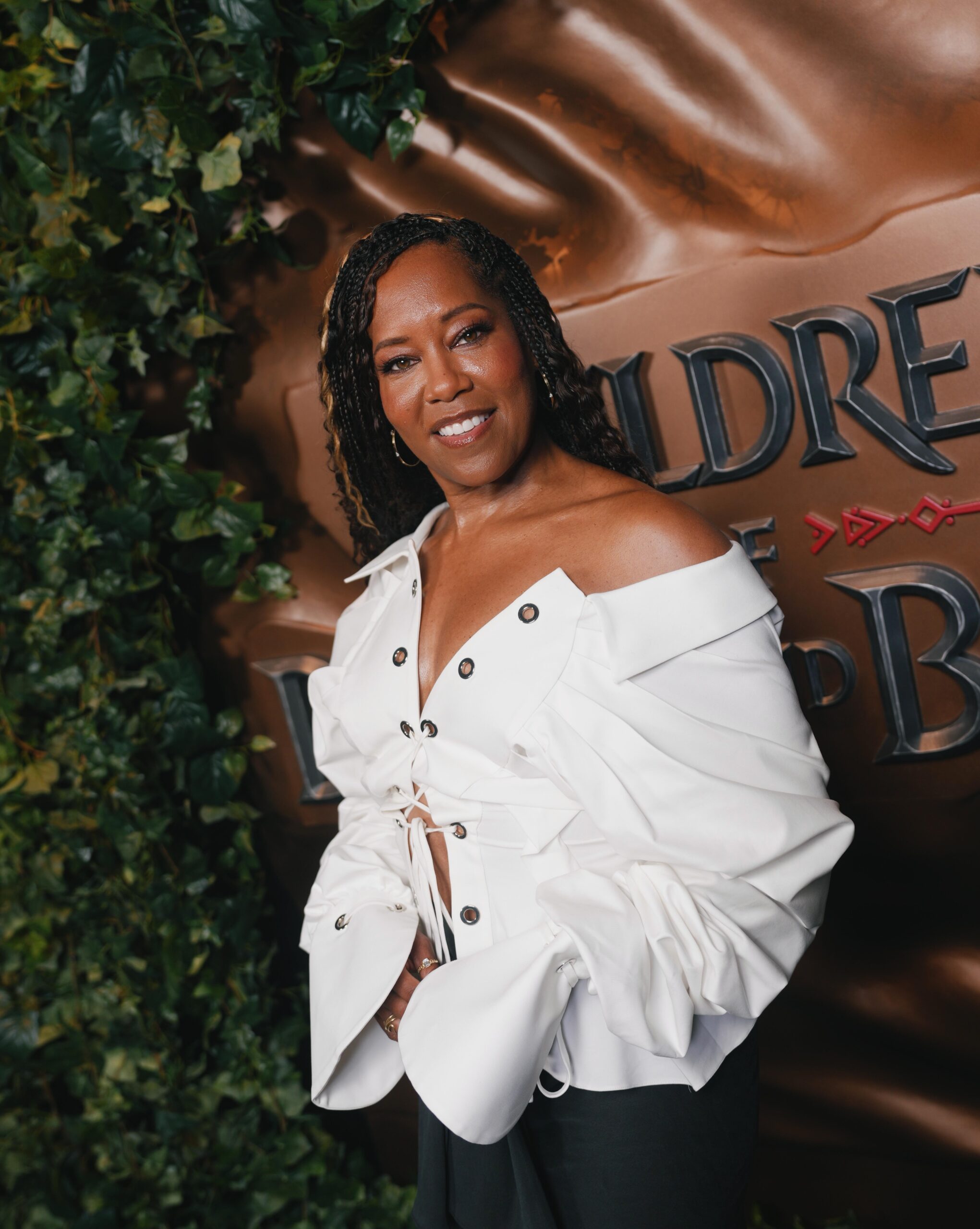 Actress Regina King wearing an off-the-shoulder white top smiling at the Children of Blood and Bone Brooklyn trailer launch event.