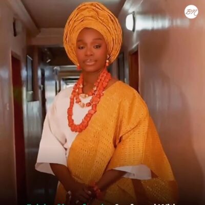 Folake Olowofoyeku wearing a white traditional outfit, gold gele, and coral beads following her chieftaincy conferment as Yeye Oba and Yeye Atayese in Ilesa, Osun State.