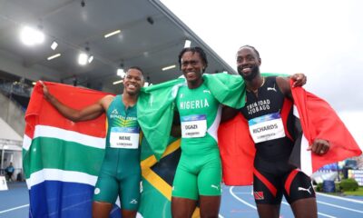 Samuel Ogazi celebrating with Nigerian flag alongside Zakithi Nene of South Africa and Jereem Richards of Trinidad and Tobago after winning men's 400m gold at Glasgow 2026 Commonwealth Games.