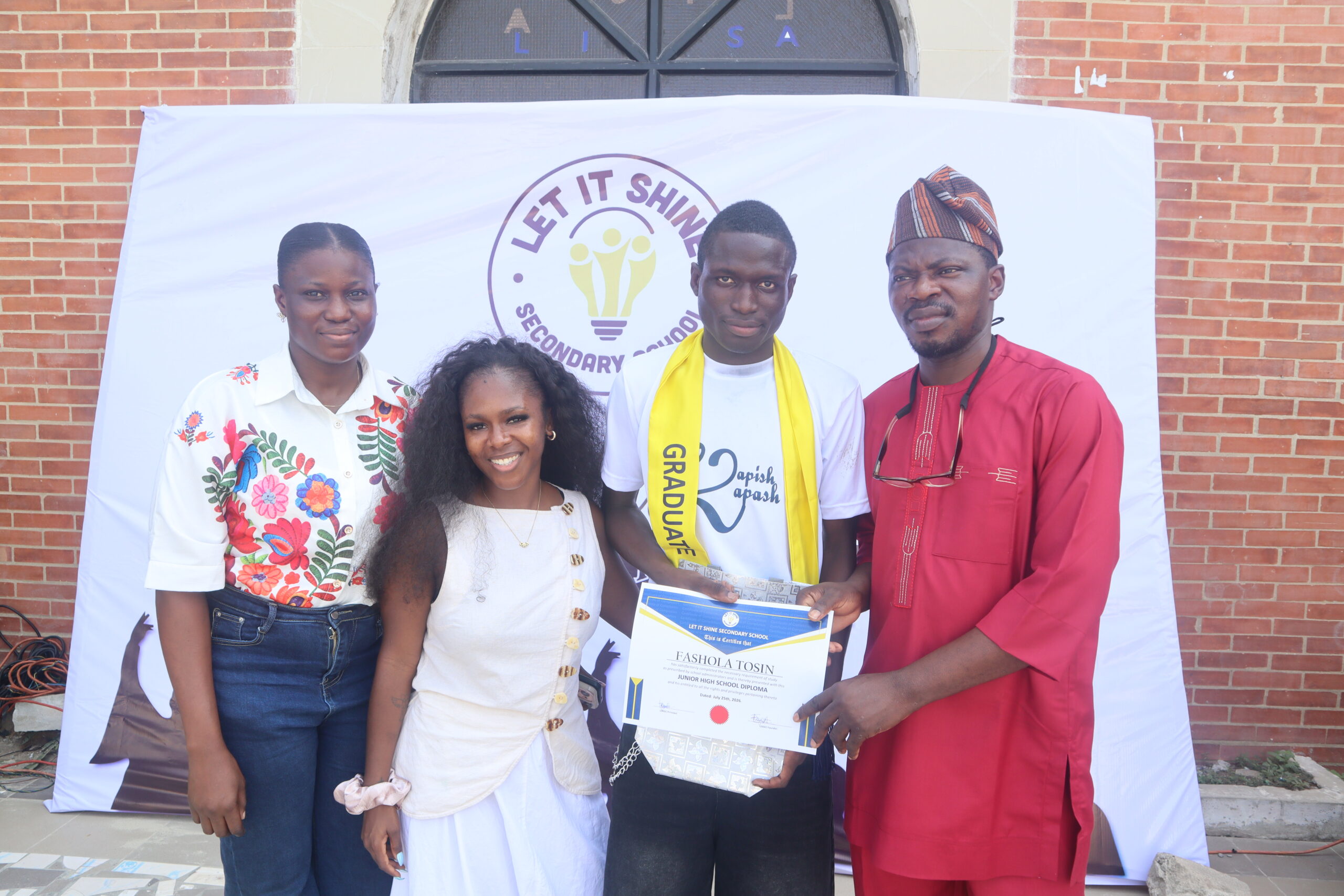 Founder Damilola Feyide and a teacher present a Junior High School Diploma certificate to student Fashola Tosin alongside a family member at Let It Shine Academy.