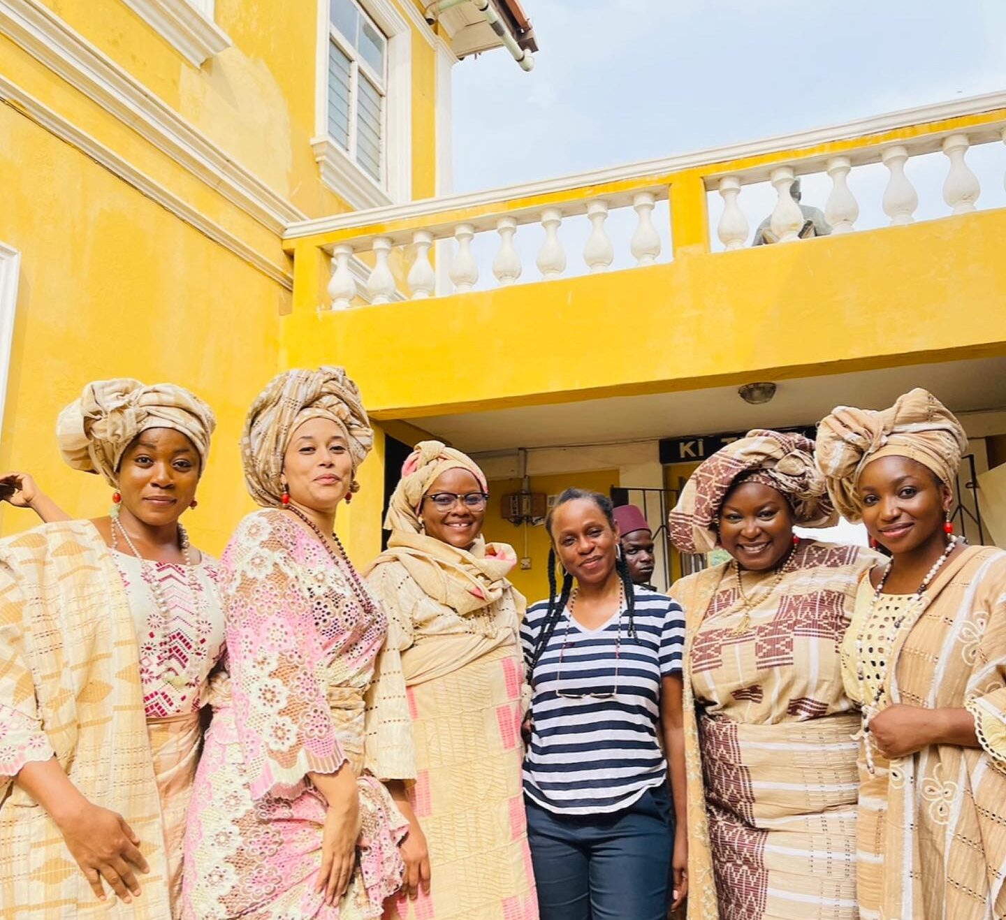 Adunni Ade in traditional Yoruba attire with cast members on the set of Funmilayo Ransome-Kuti.