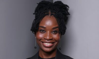 Nigerian filmmaker and writer Uzoamaka Power smiling in a black suit jacket and braided updo hairstyles, director of the short film Siraam.