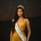 Gift Eno Ndah wearing a tiara, official sash, and gold sequined dress as Miss Supranational Nigeria 2026.