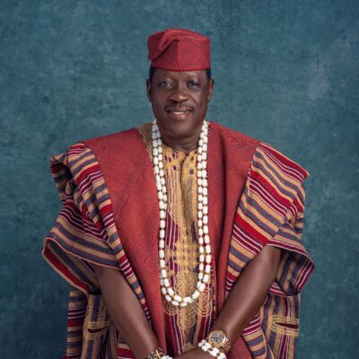 Memorial photo of Nollywood actor Taiwo Hassan Ogogo wearing traditional red Aso-Oke Agbada and white coral beads.