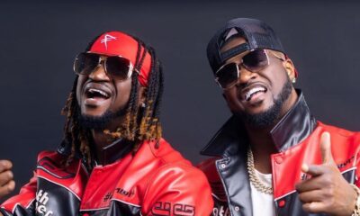 Peter and Paul Okoye of P-Square posing in matching red and black leather biker jackets, sunglasses, and gold chains.
