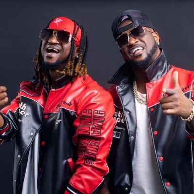 Peter and Paul Okoye of P-Square posing in matching red and black leather biker jackets, sunglasses, and gold chains.