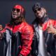 Peter and Paul Okoye of P-Square posing in matching red and black leather biker jackets, sunglasses, and gold chains.