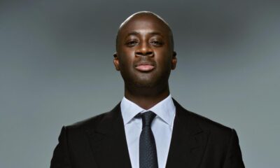 Slovan Bratislava head coach Yaya Touré holding a soccer ball in both hands.