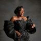 Nollywood actress Funke Akindele smiling in an embellished black corset gown with statement exaggerated sleeves.