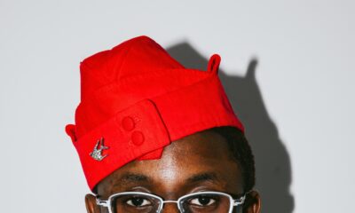 Nigerian singer Victony wearing glasses and a red cap in a portrait photo