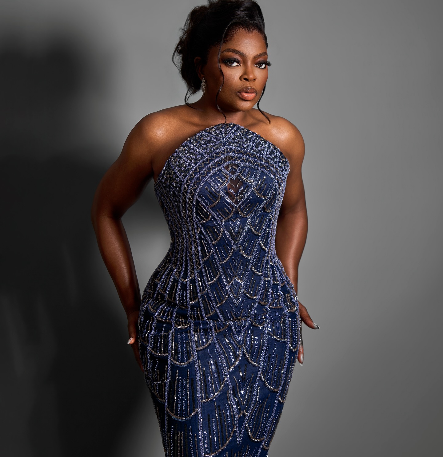 Medium portrait of Funke Akindele in a navy blue beaded corset gown.