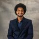 BBNaija housemate Chimsom Chuka posing in a navy blue double-breasted suit jacket with an afro hairstyle.