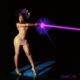 Ayra Starr in a purple gele and metallic dress shooting a pink beam for Starrgirl album cover