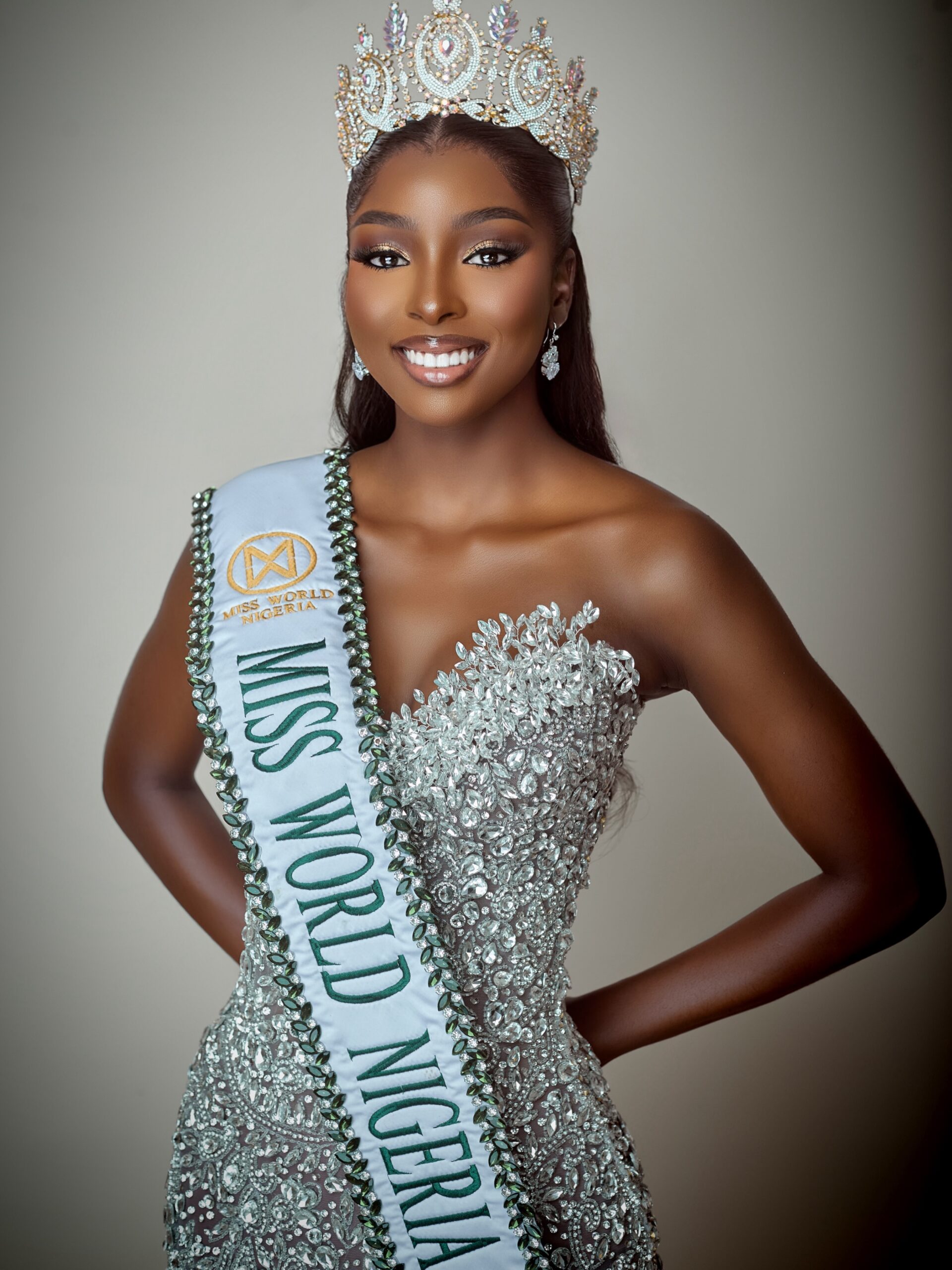 Tamunosoye Karibi-George smiling wearing a jewelled crown, a heavily embellished silver gown, and the Miss World Nigeria sash.