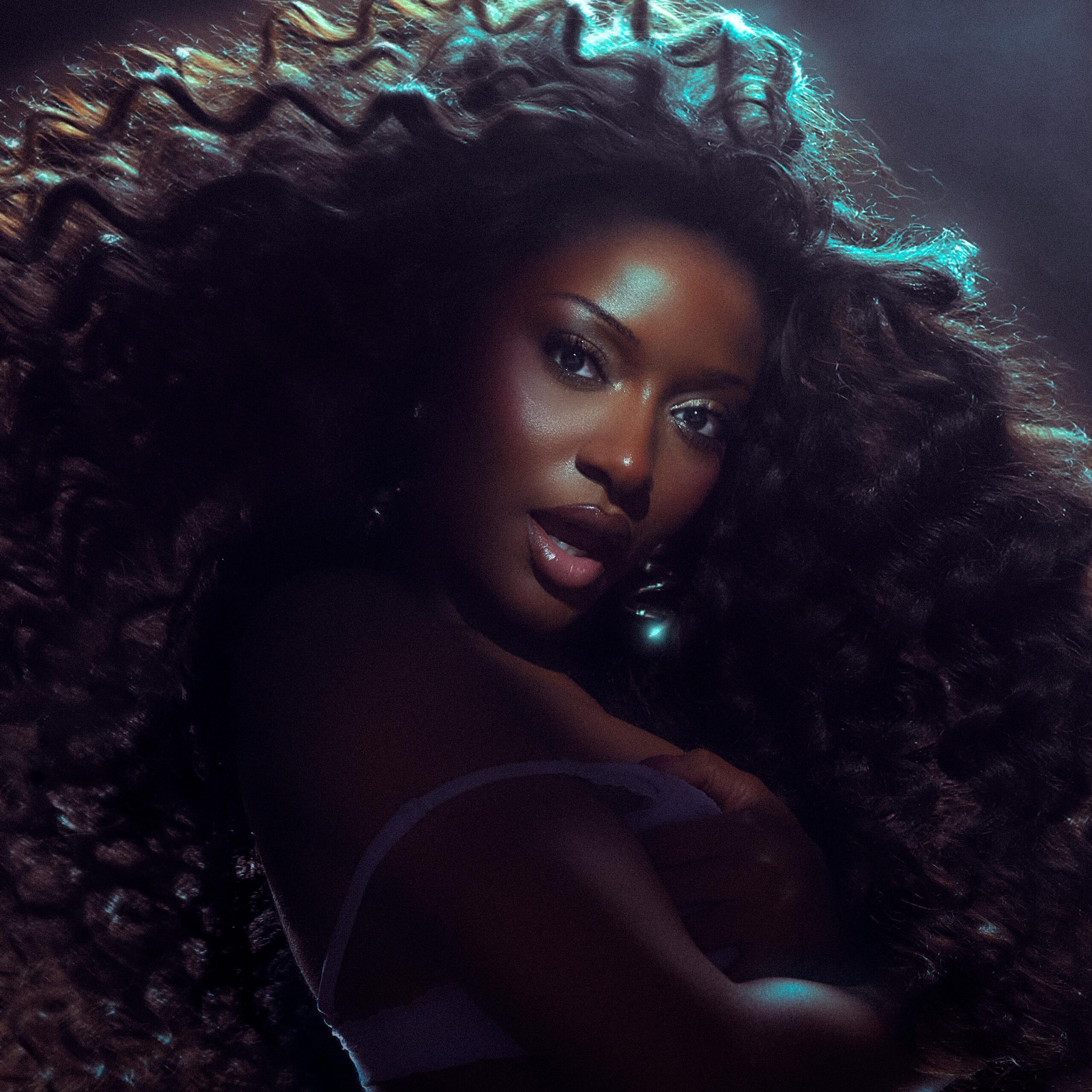 Ayra Starr posing with voluminous curly hair for a promo shoot.