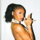 Ayra Starr posing with finger gun gesture wearing a crystal choker and high ponytail.