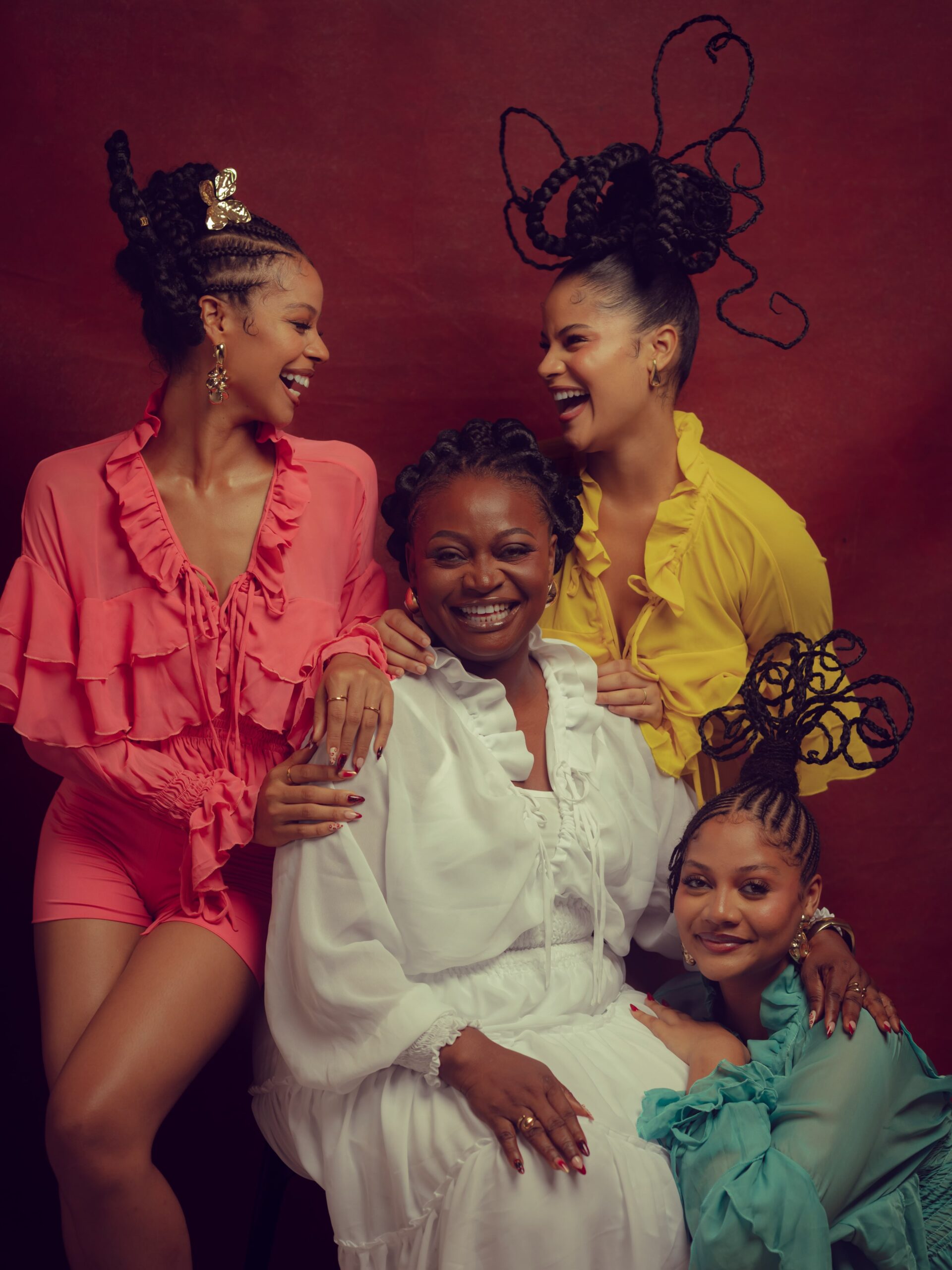 The Rosman mother seated in a white ruffled dress surrounded by daughters Nwadiuto, Sunshine, and Honey laughing together.