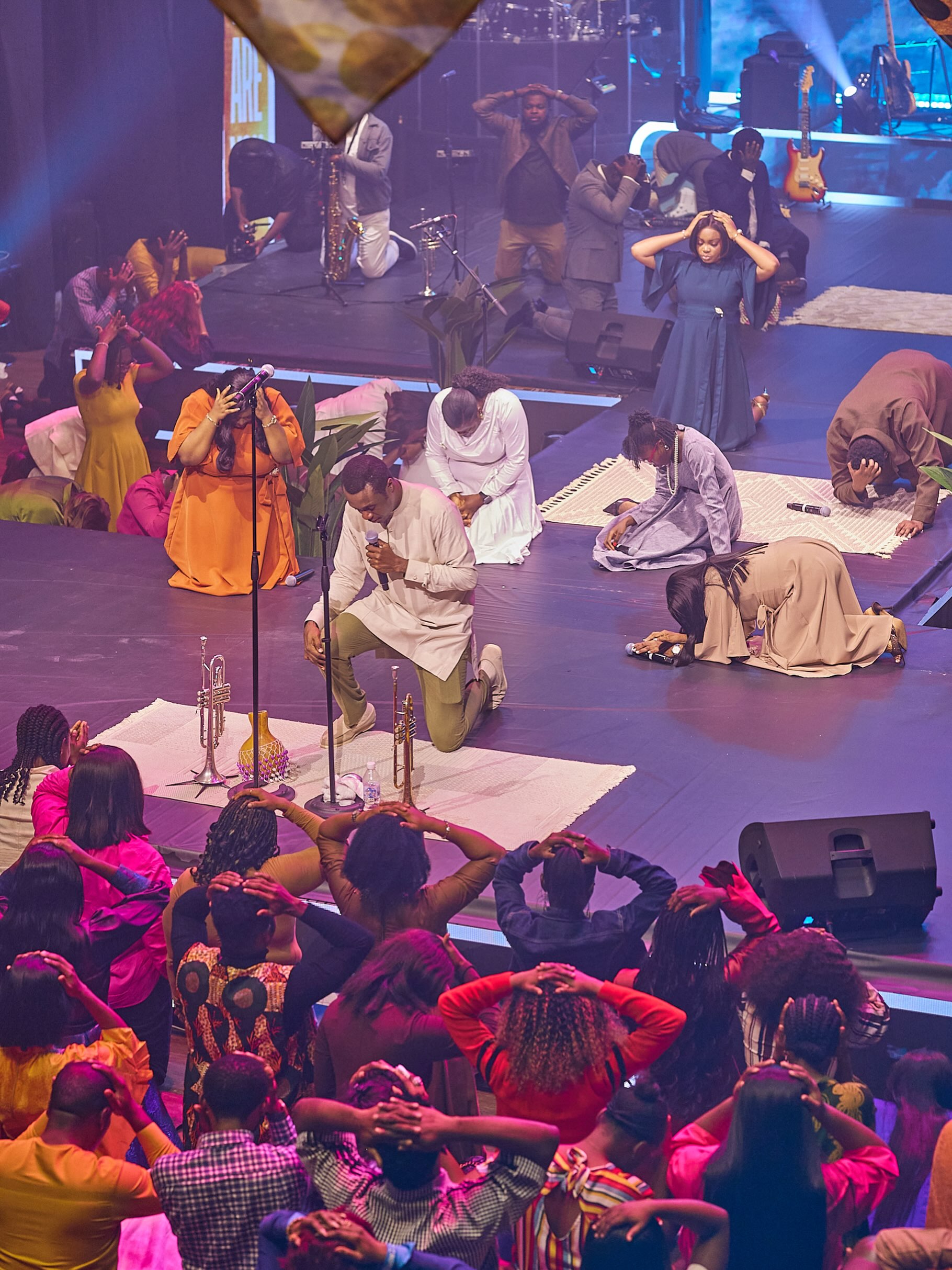Nathaniel Bassey kneeling in worship during The Battle Belongs to God live recording