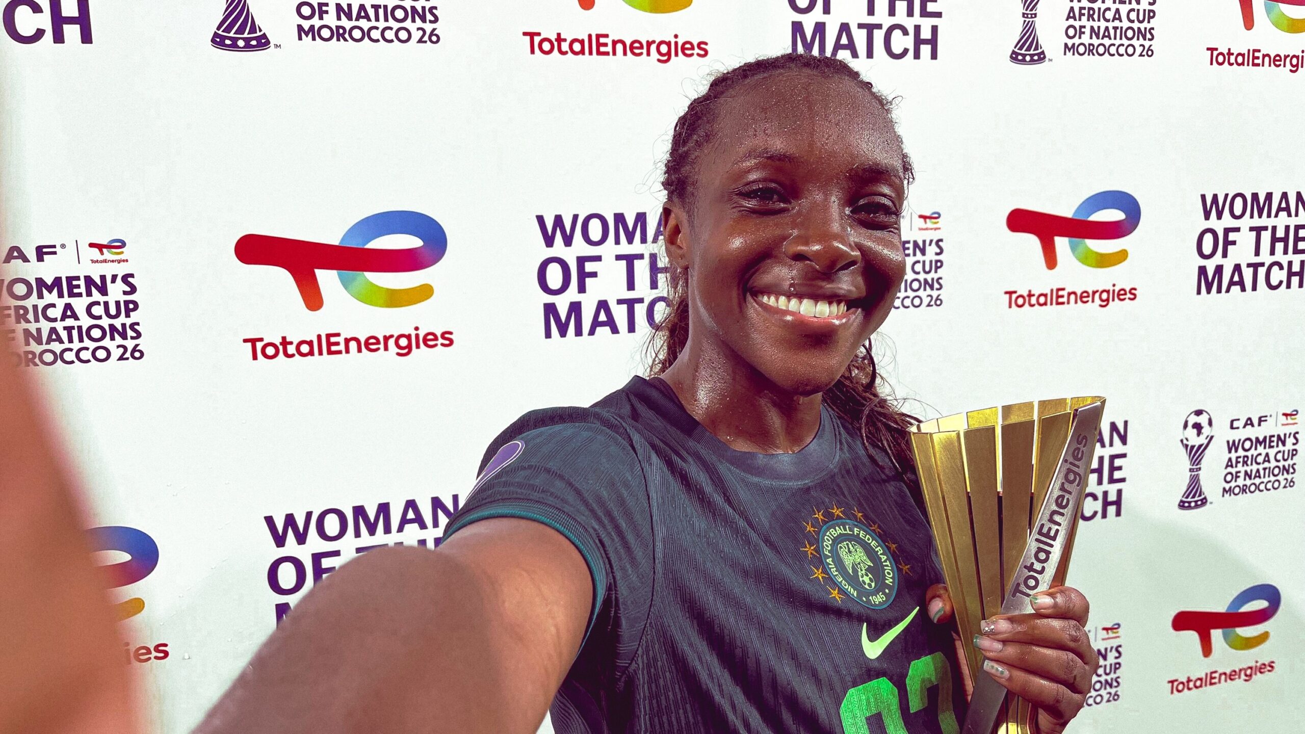 Super Falcons defender Michelle Alozie smiling while holding her Woman of the Match award following Nigeria's 1-0 win against Zambia at WAFCON 2026.