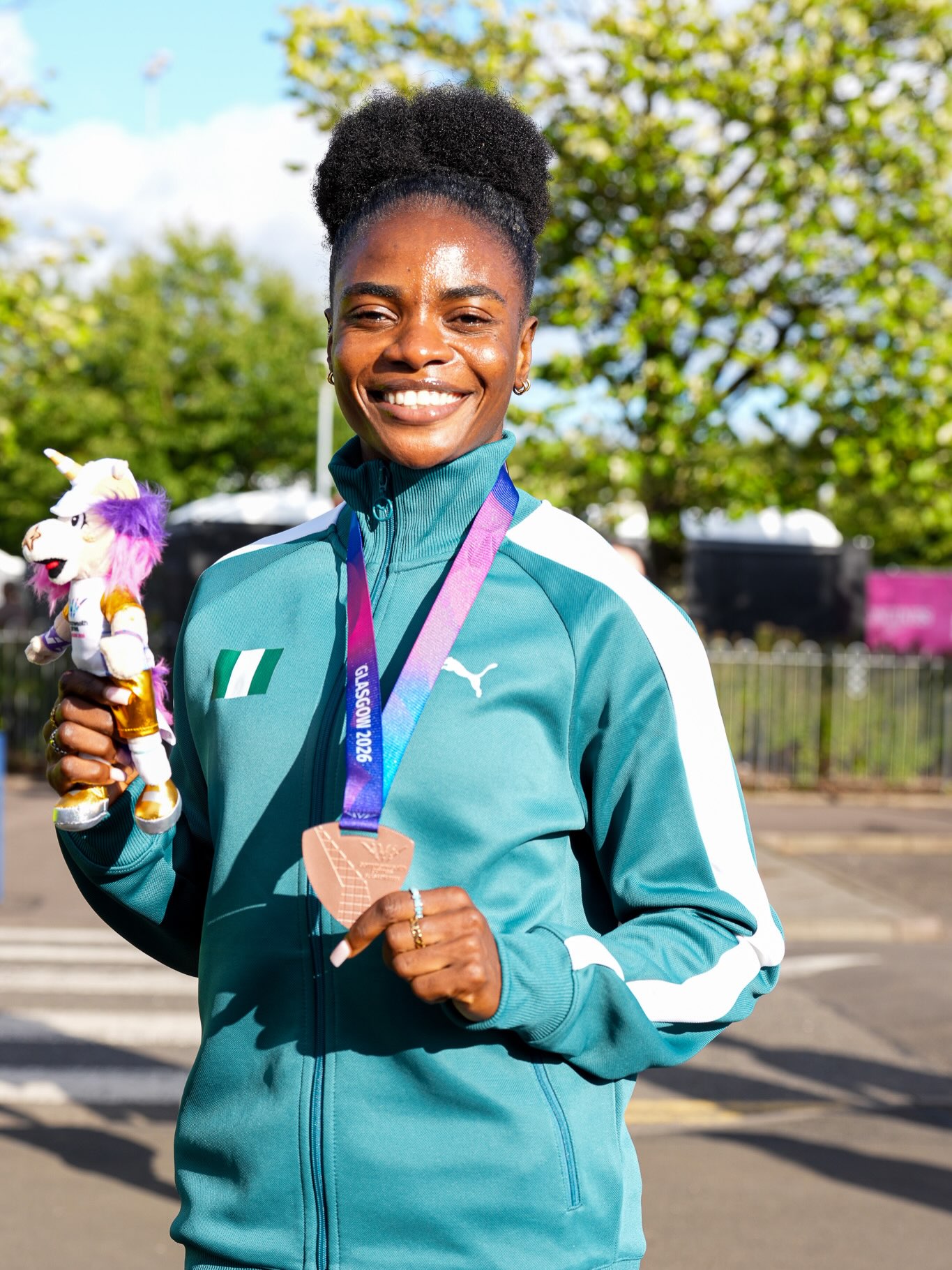 Tobi Amusan smiling with her bronze medal and official mascot at the Glasgow 2026 Commonwealth Games.