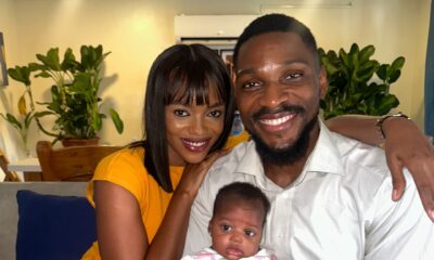 Tobi Bakre and Onyinye Odokoro smiling on a sofa while holding a baby on set of Before We Fall Asleep.
