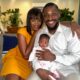 Tobi Bakre and Onyinye Odokoro smiling on a sofa while holding a baby on set of Before We Fall Asleep.