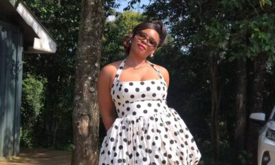 Yemi Alade posing in a white halterneck polka dot mini dress with a structured corseted bodice and bubble skirt.