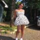 Yemi Alade posing in a white halterneck polka dot mini dress with a structured corseted bodice and bubble skirt.
