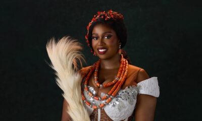 Temi Nkem wearing off-shoulder white lace attire paired with multi-layer coral necklaces and coral hair accessories.
