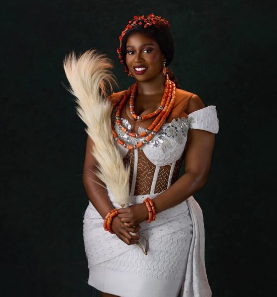 Temi Nkem wearing off-shoulder white lace attire paired with multi-layer coral necklaces and coral hair accessories.