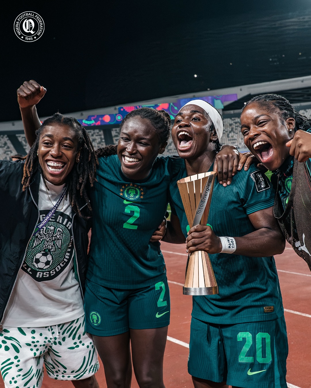 Super Falcons squad members embracing and cheering alongside the Woman of the Match trophy after defeating Egypt 6-2.