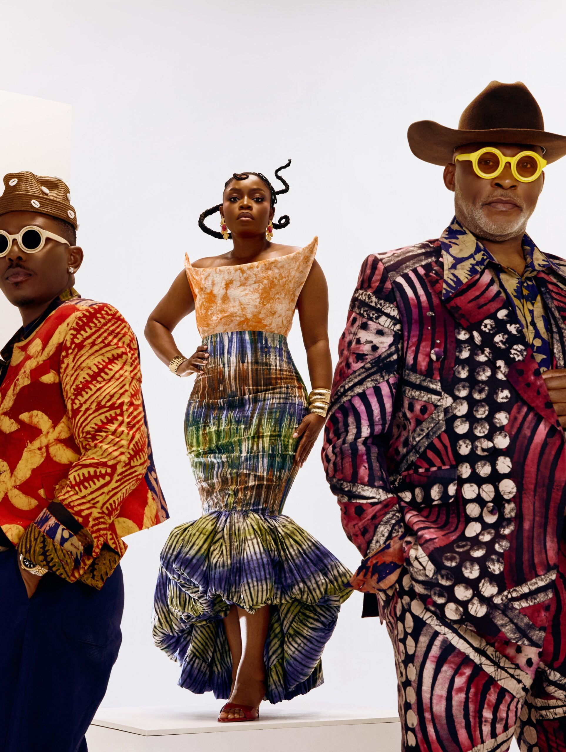 Timini Egbuson, Bisola Aiyeola, and Richard Mofe-Damijo wearing custom Adire tailored suits and a Fleur poof skirt.