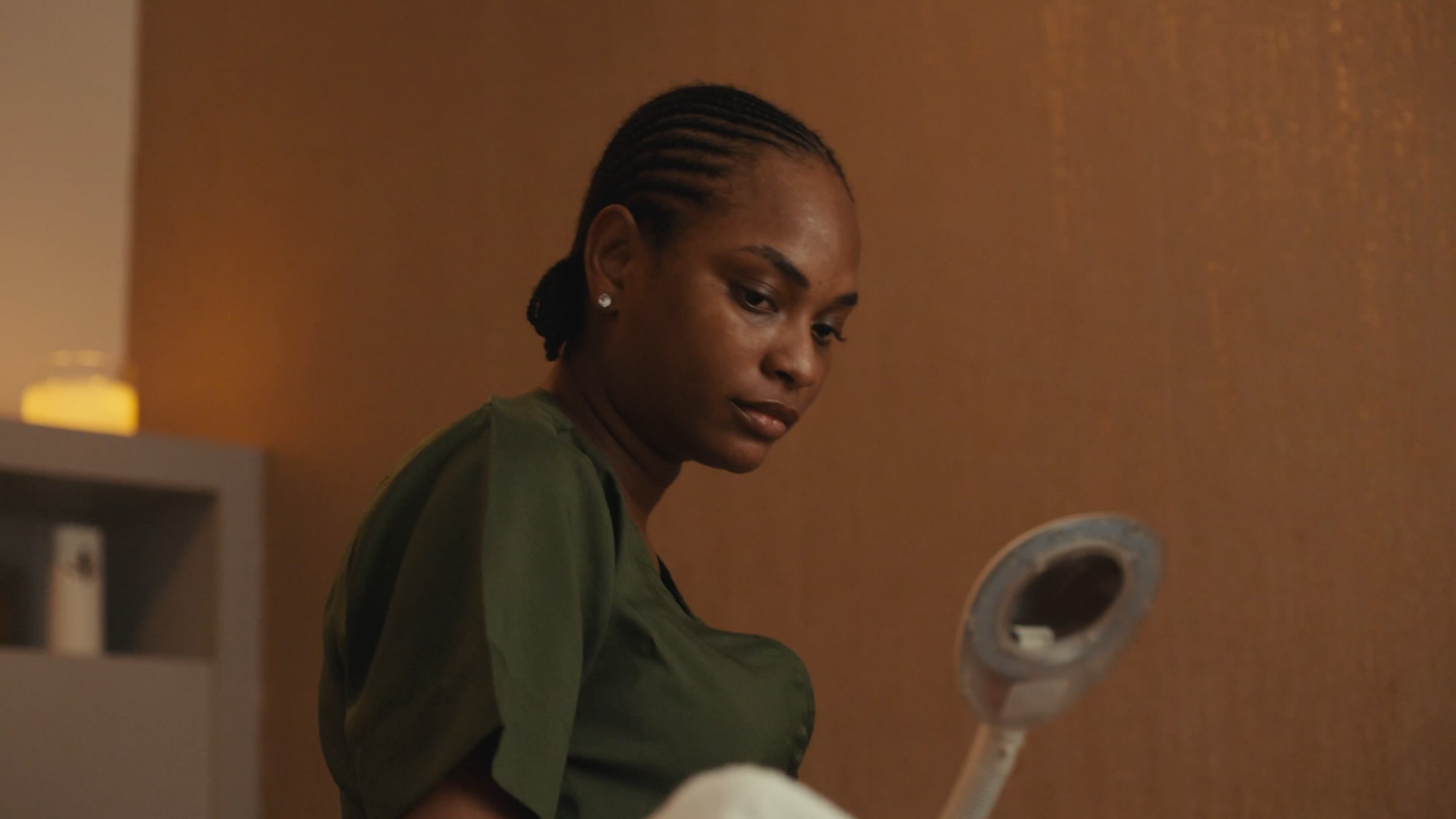 Film still from Dika Ofoma's A Happy Ending showing a character working in a spa setting.