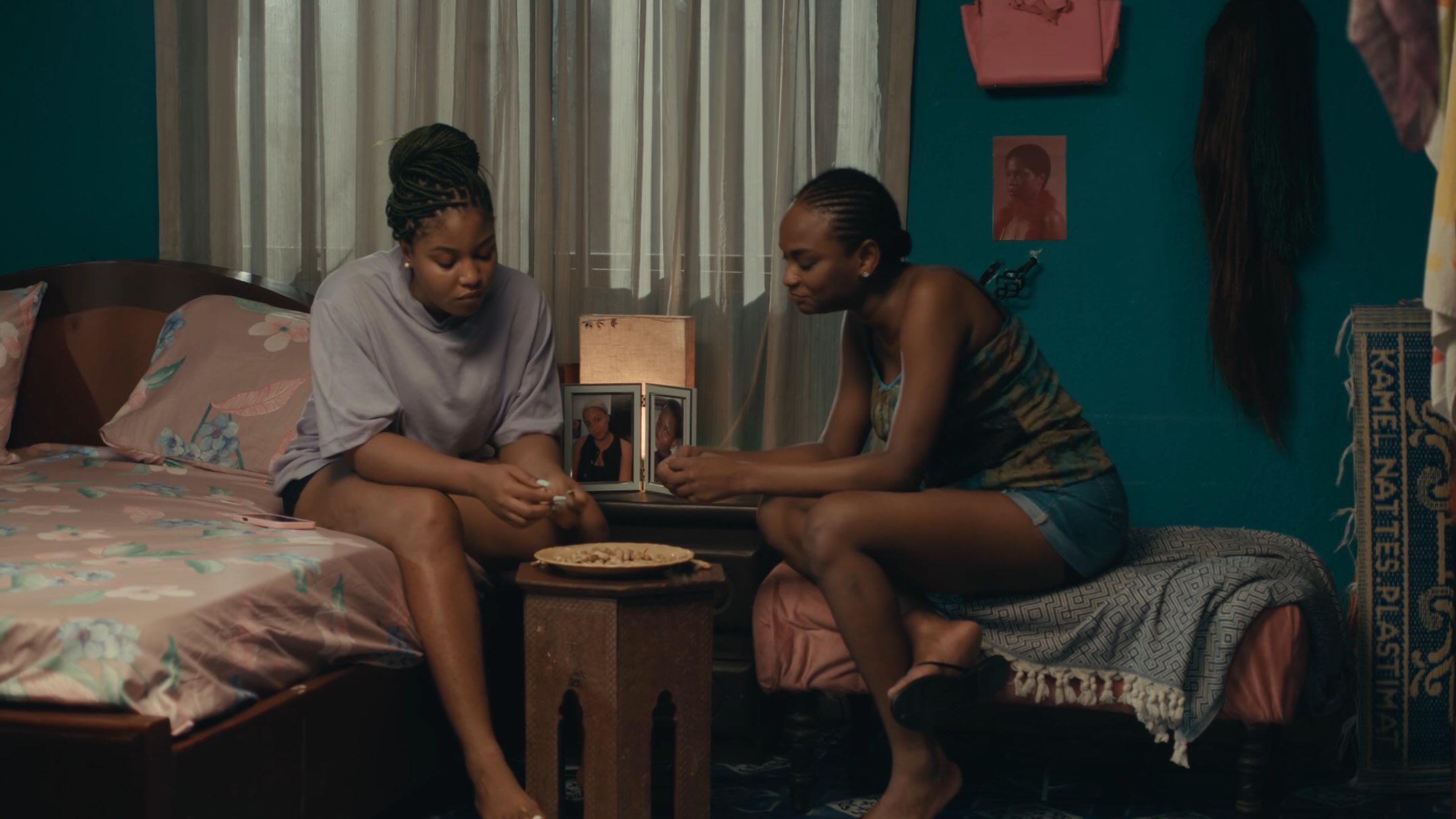 Film still from Dika Ofoma's A Happy Ending showing two female characters conversing in a bedroom.