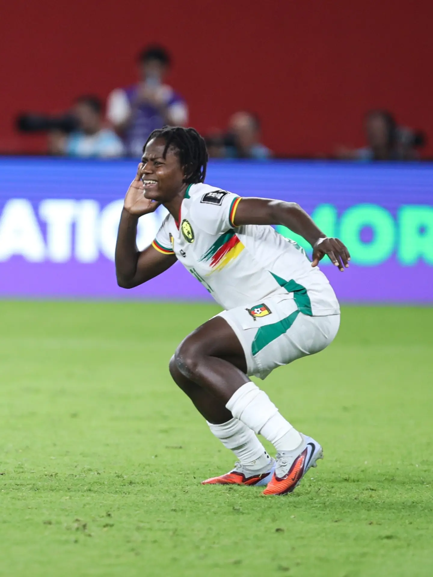 Cameroon forward Myriam Maéva Nyadjou celebrating on the pitch in her white national team kit during WAFCON 2026 in Morocco.