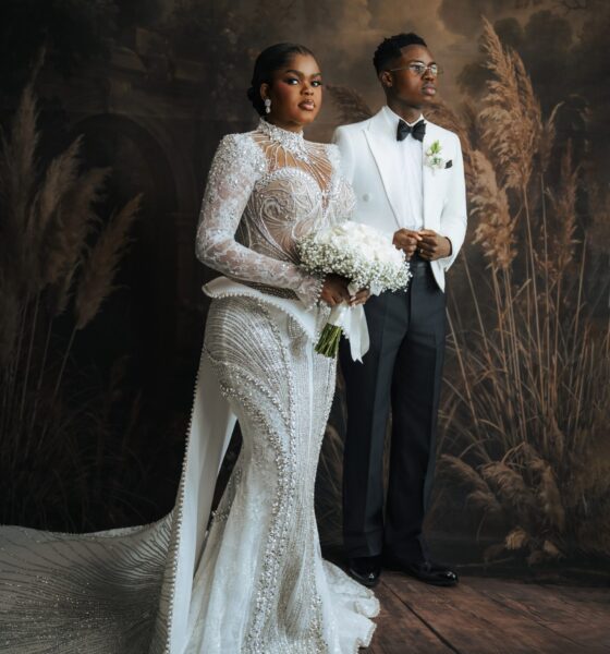 Peller and Jarvis posing together in their white wedding outfits.