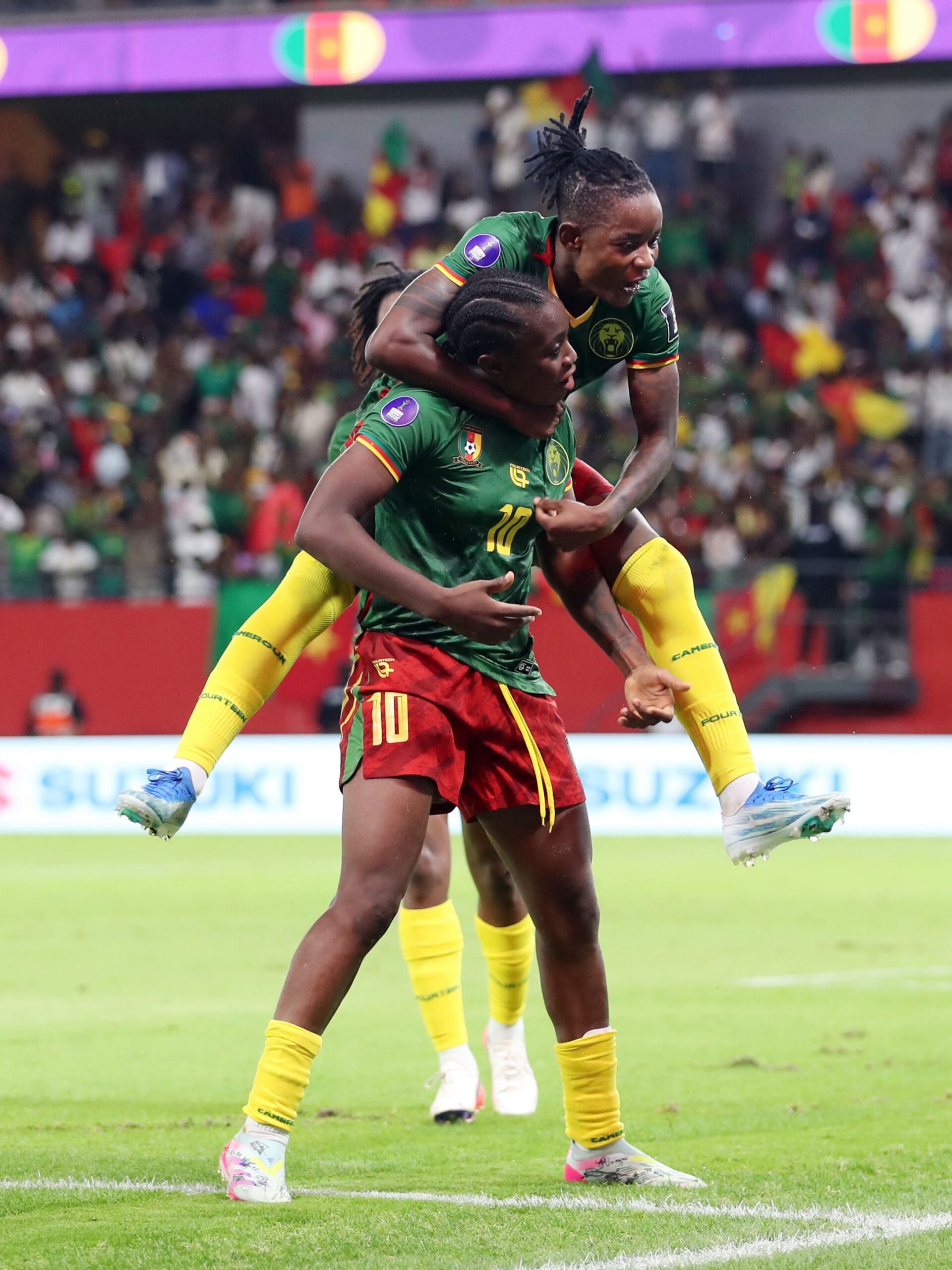 Naomi Eto carrying Marie Ngah on her back while celebrating Cameroon's goal against Malawi in the WAFCON 2026 final.