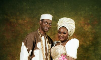 Close-up portrait of Lateef Adedimeji and Mo Bimpe smiling together in traditional Nigerian cream and gold outfits.