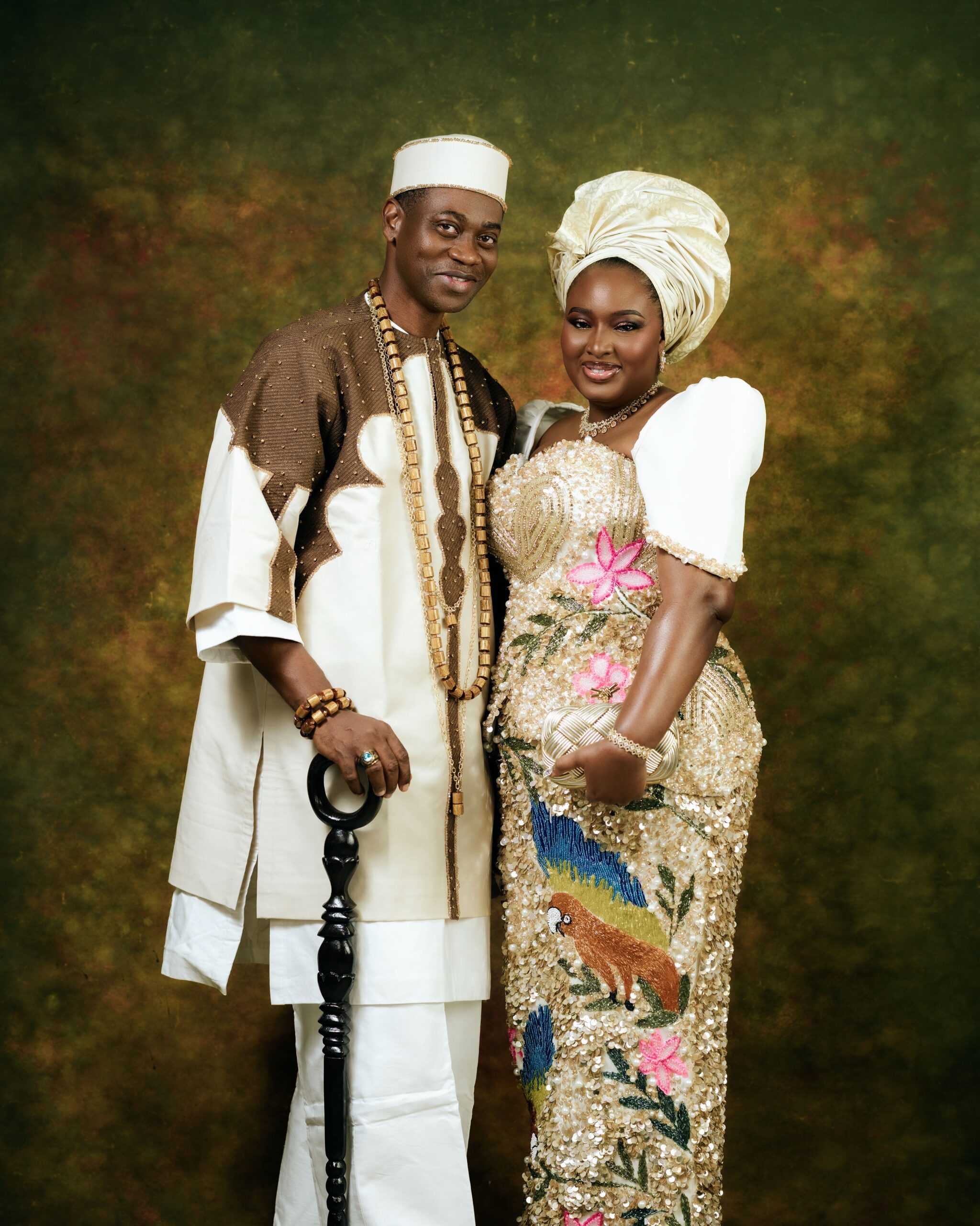 Close-up portrait of Lateef Adedimeji and Mo Bimpe smiling together in traditional Nigerian cream and gold outfits.