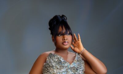 Mo Bimpe showing her topknot hair, glossy glam, and metallic sequin gown details.