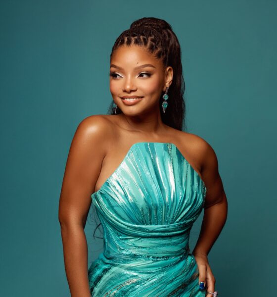 Halle Bailey posing in a strapless metallic teal Valdrin Sahiti dress with shell pleated bust.