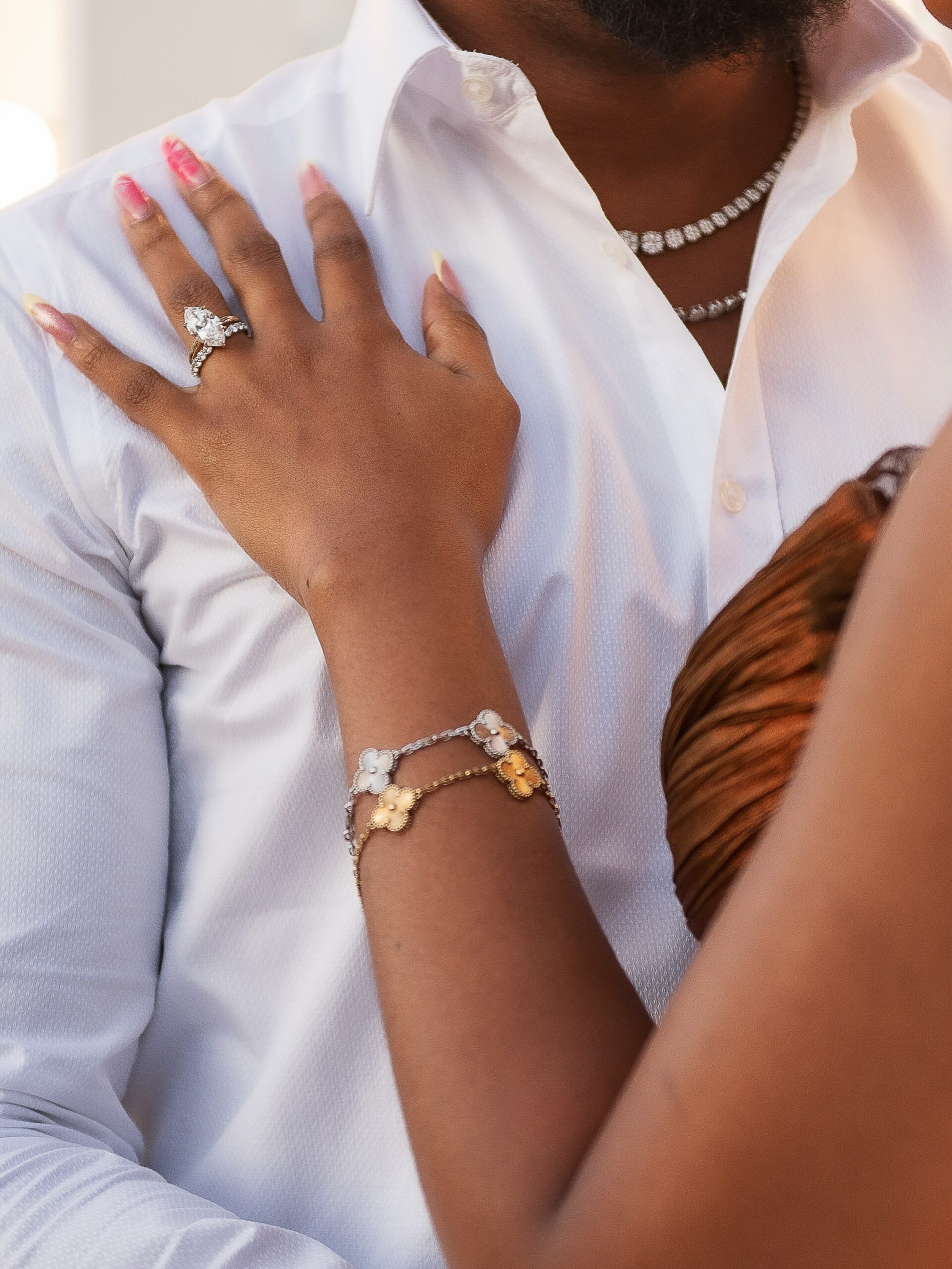 Marquise-cut diamond engagement ring on Diana Eneje hand resting on her partner's white shirt.