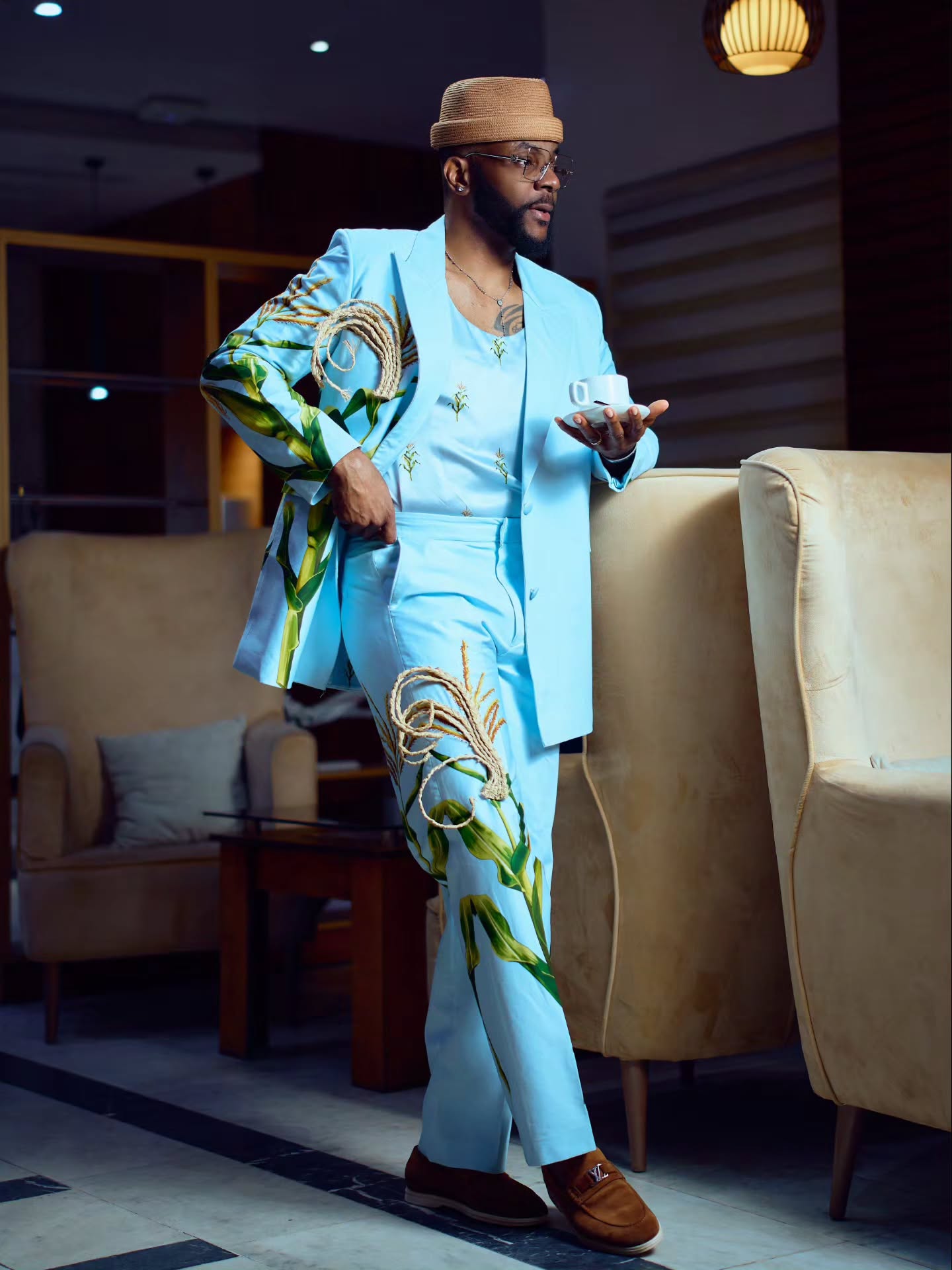 Ebuka Obi-Uchendu wearing a sky-blue double-breasted suit with wide-leg trousers and brown suede loafers.