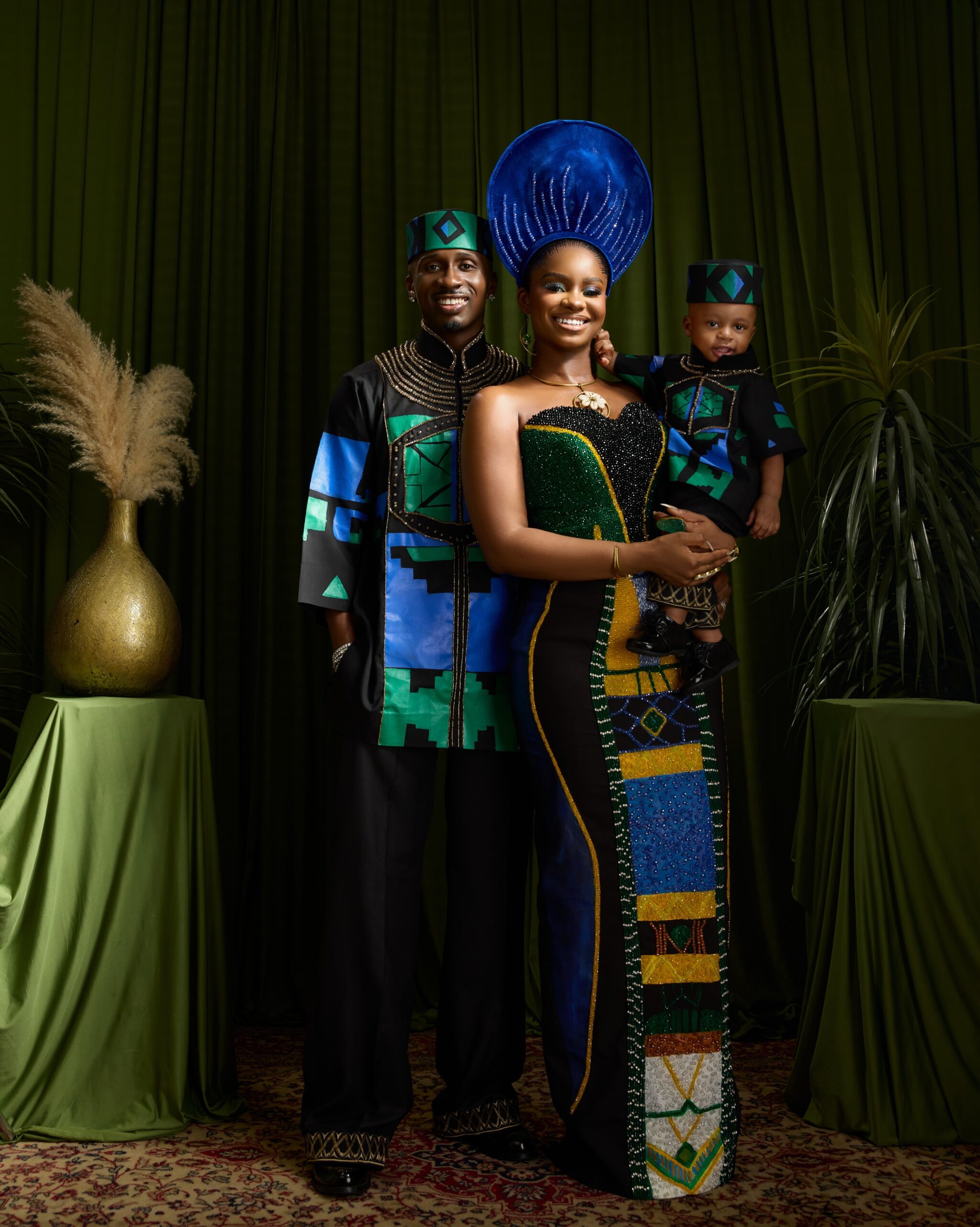 Priscilla Ojo and Juma Jux smiling at the camera holding baby Rakeem.