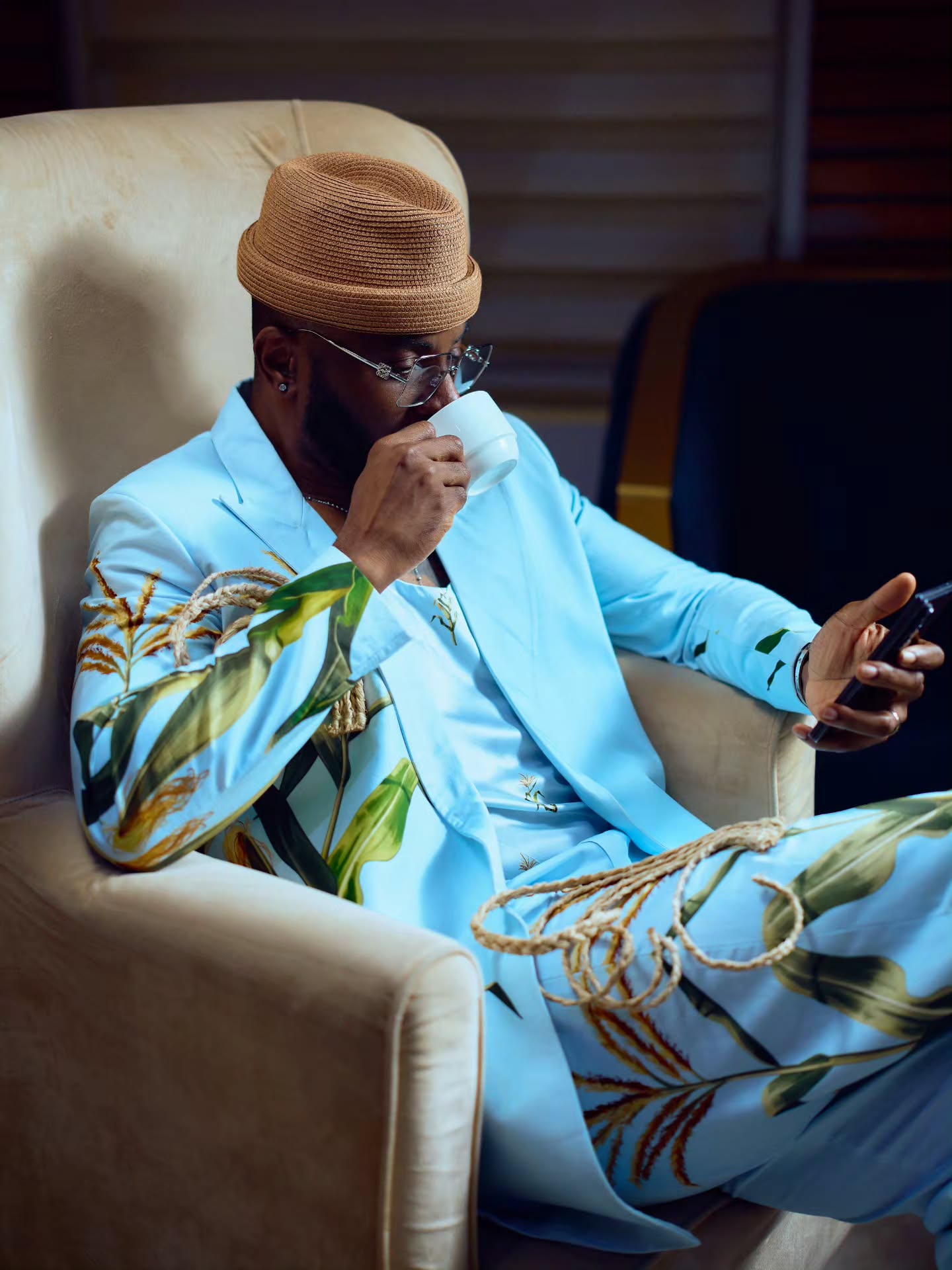 Ebuka Obi-Uchendu wearing a blue scoop-neck vest with maize kernel embroidery and wire-rimmed glasses.