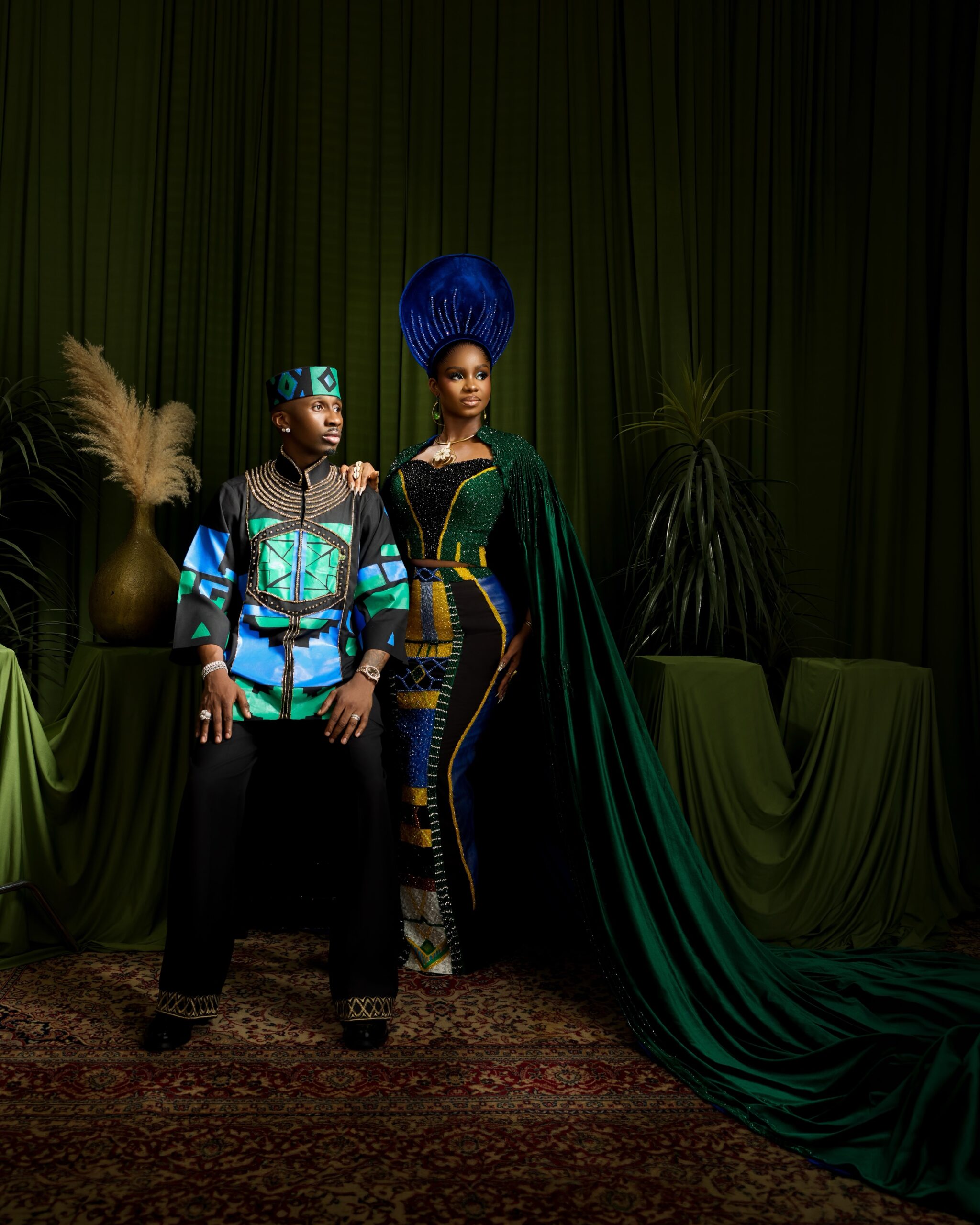 Priscilla Ojo in a beaded green cape gown standing beside Juma Jux in a black and teal patterned tunic.